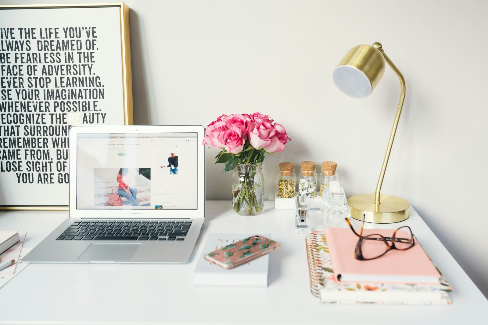 Impact of Home Clutter on Mental Health 2 MacBook Air beside gold-colored study lamp and spiral books